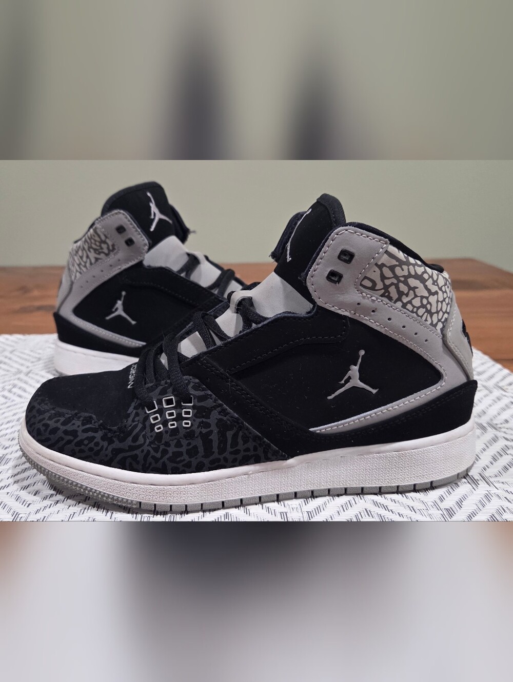 Nike Jordan 1 Flight Mid sneakers in a black, gray, and elephant print colorway.